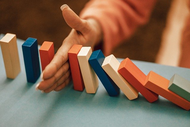 Main qui arrête des dominos